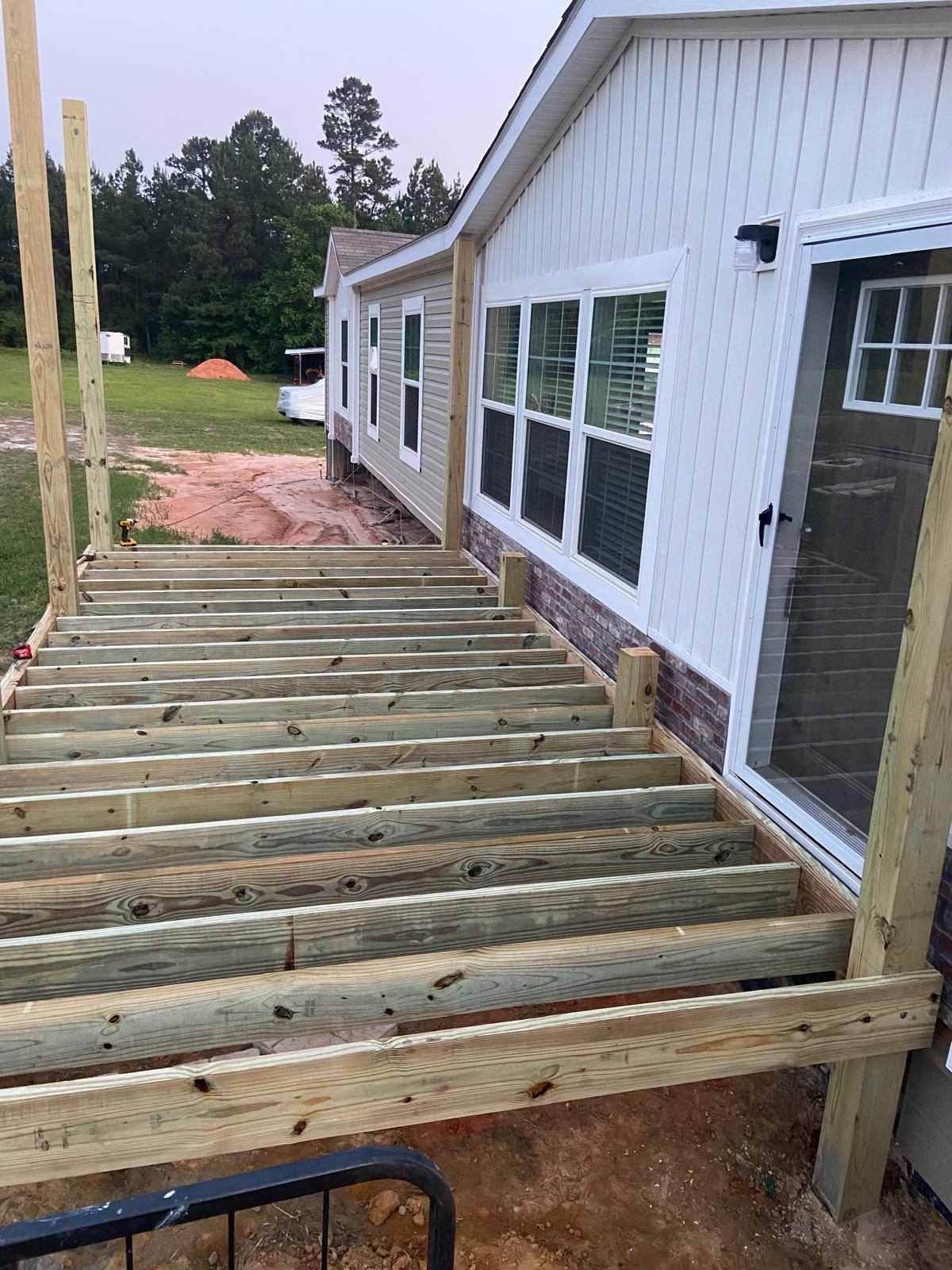 Rear deck addition being framed onto a home