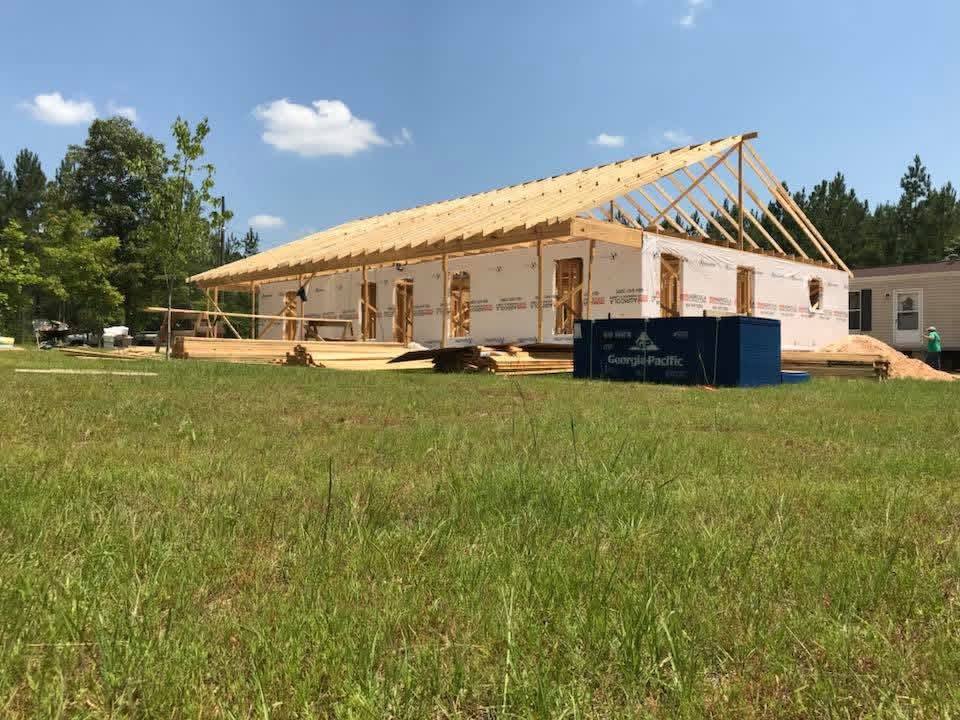 New home under construction with roof trusses being framed